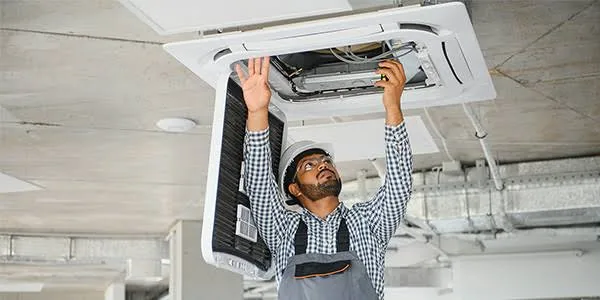 Technician servicing a ceiling cassette air handler