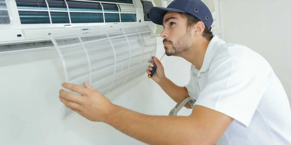Technician cleaning an indoor air conditioner filter