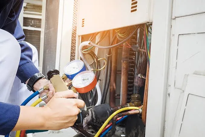Technician using refrigerant gauges on HVAC equipment