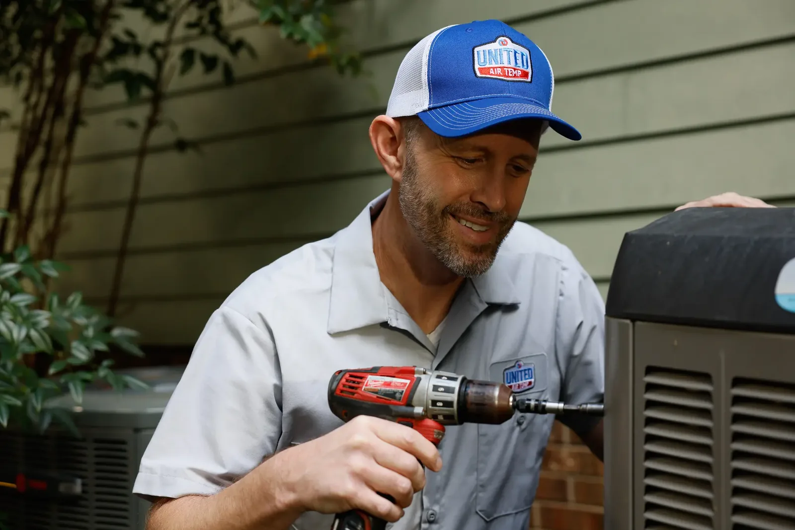 HVAC technician working on an outdoor air conditioning unit