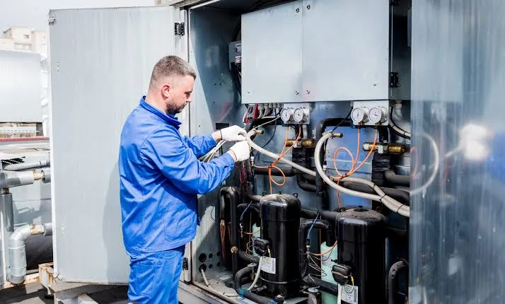 Technician working on heating and cooling plant equipment